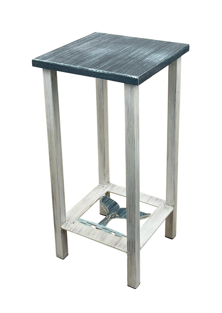 Our Weathered Nautical Whale Tail Accent Table, made of iron and wood, will add a touch of nautical charm to your home.  It features a weathered white iron frame, iron navy blue whale tail shelf, and weather navy blue wood top, this versatile piece can serve as an accent, side, or drink table. Perfect for any occasion and proudly made in the USA! This custom made to order piece takes 3-4 week to perfect. Size is 11" square x 23" tall. 